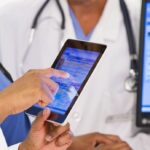 Profissional de saúde utilizando tablet para consulta de telessaúde e prontuário digital no SUS
