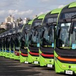 Frota de ônibus elétricos municipais alinhada em garagem com infraestrutura de eletropostos e recarga