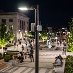 Poste de iluminação pública em LED com antena 5G e roteador Wi-Fi integrado iluminando praça municipal à noite