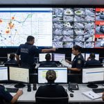 Operadores do Centro de Controle Operacional municipal monitorando mapa da cidade e telas de videomonitoramento com inteligência artificial e leitores de placas OCR